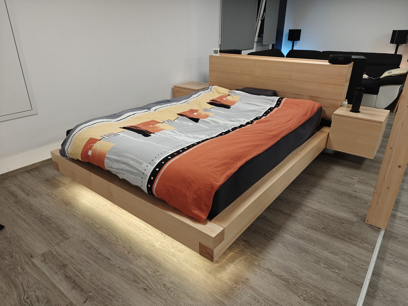 Schwebendes Bettsystem mit LED-Beleuchtung von unten, beide Nachttische montiert, Sprossenwand im Hintergrund