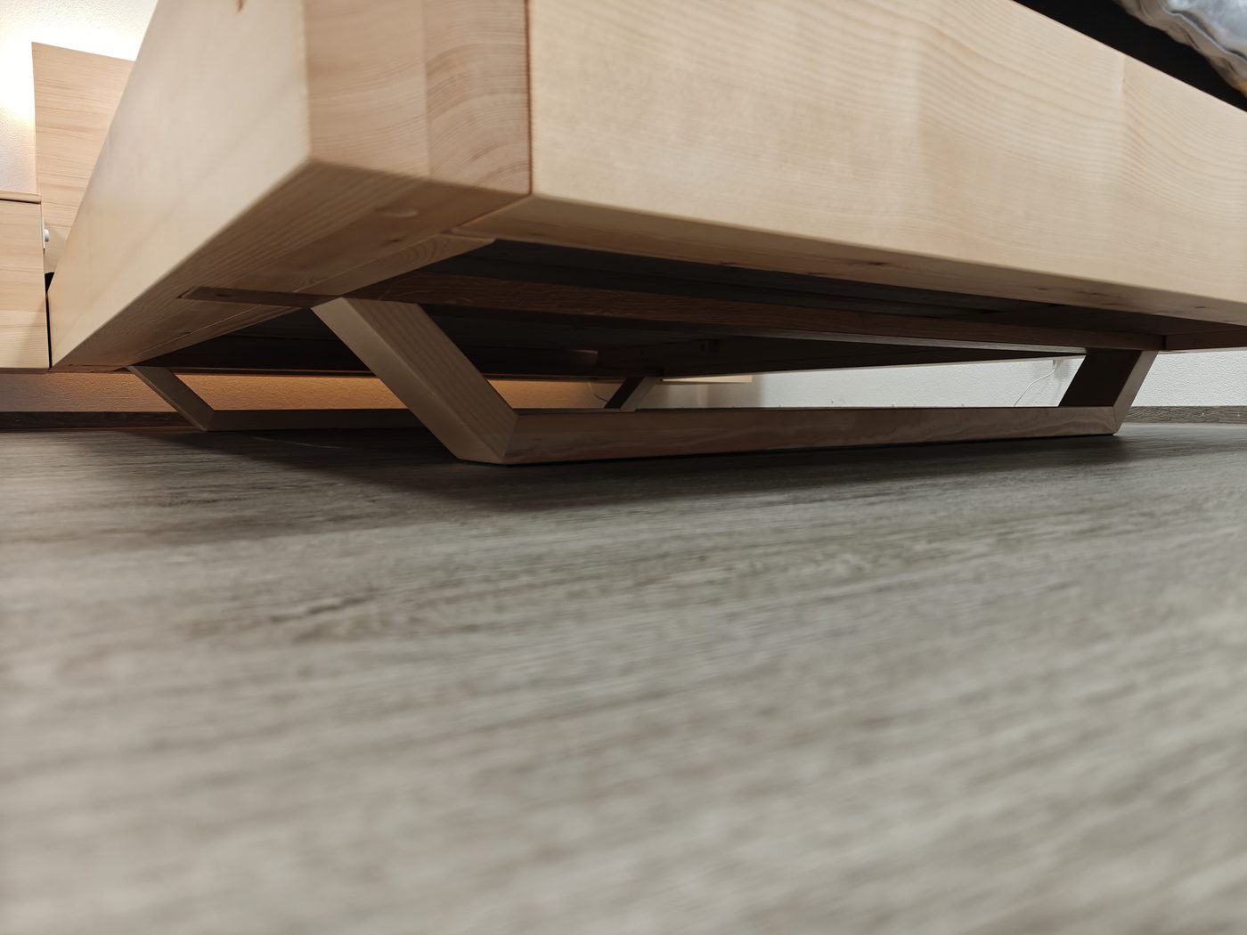 V-förmige Fussstreben unter dem Bettrahmen — nach innen versetzt, von aussen unsichtbar